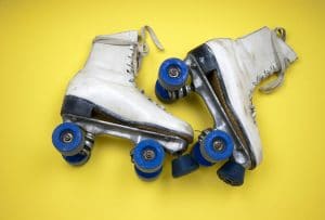 white skates with blue wheels on a yellow background